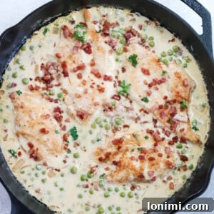 Chicken and peas with prosciutto in a cream sauce in a cast iron skillet