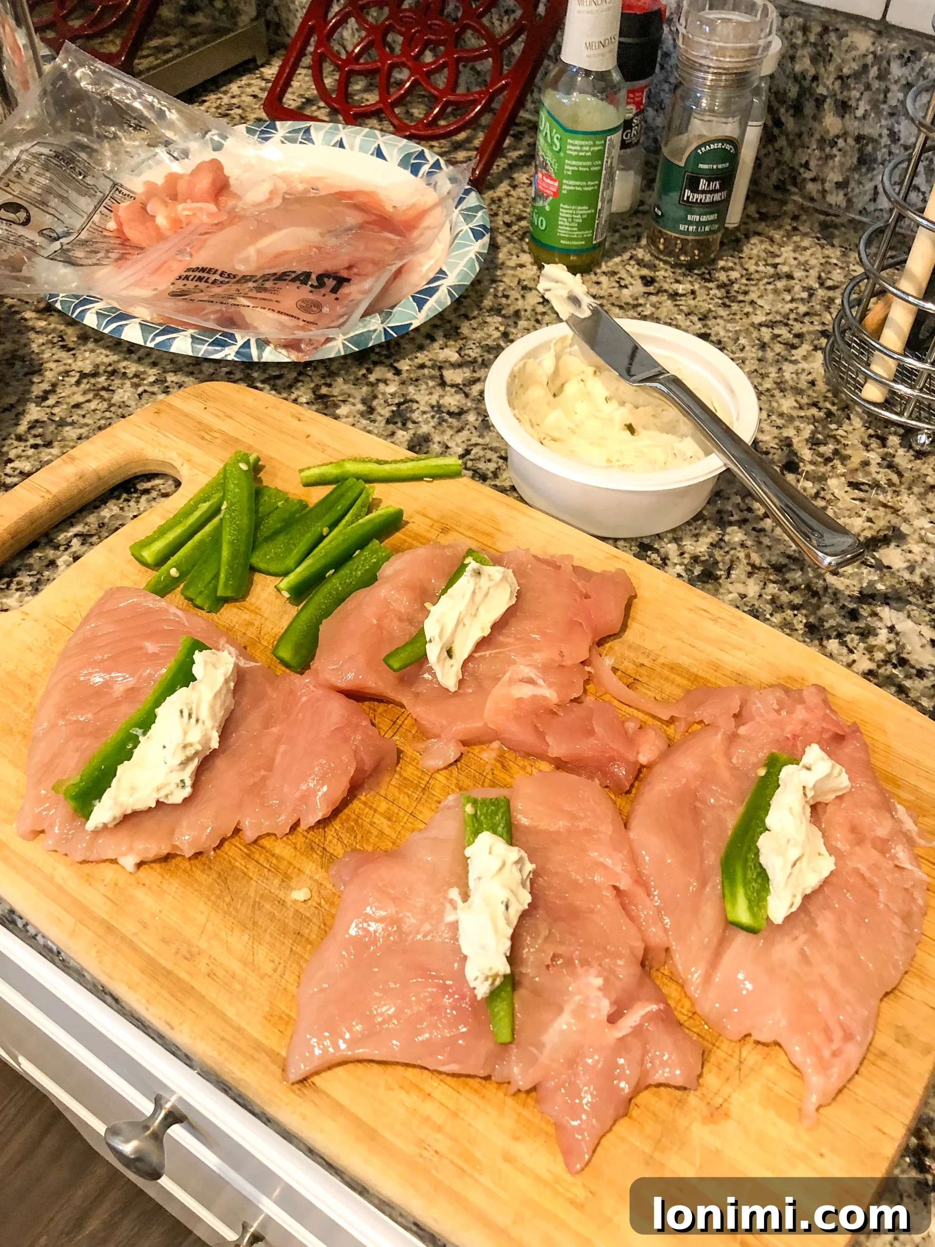 Paleo Bacon-Wrapped Jalapeño Chicken 3 Prepped chicken breasts filled with cream cheese and jalapeno, ready to be wrapped in bacon.