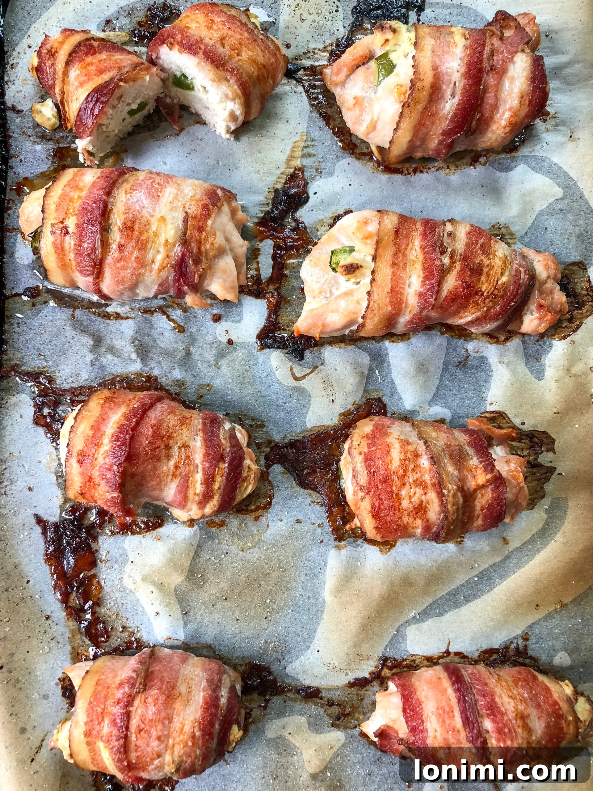 Paleo Bacon-Wrapped Jalapeño Chicken 4 Golden brown Bacon-Wrapped Jalapeno Popper Chicken baking in the oven.