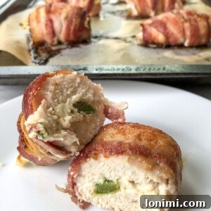 Paleo Bacon-Wrapped Jalapeño Chicken 5 Close-up of a cooked Bacon-Wrapped Jalapeno Popper Chicken roll-up, showcasing its crispy bacon and creamy filling.