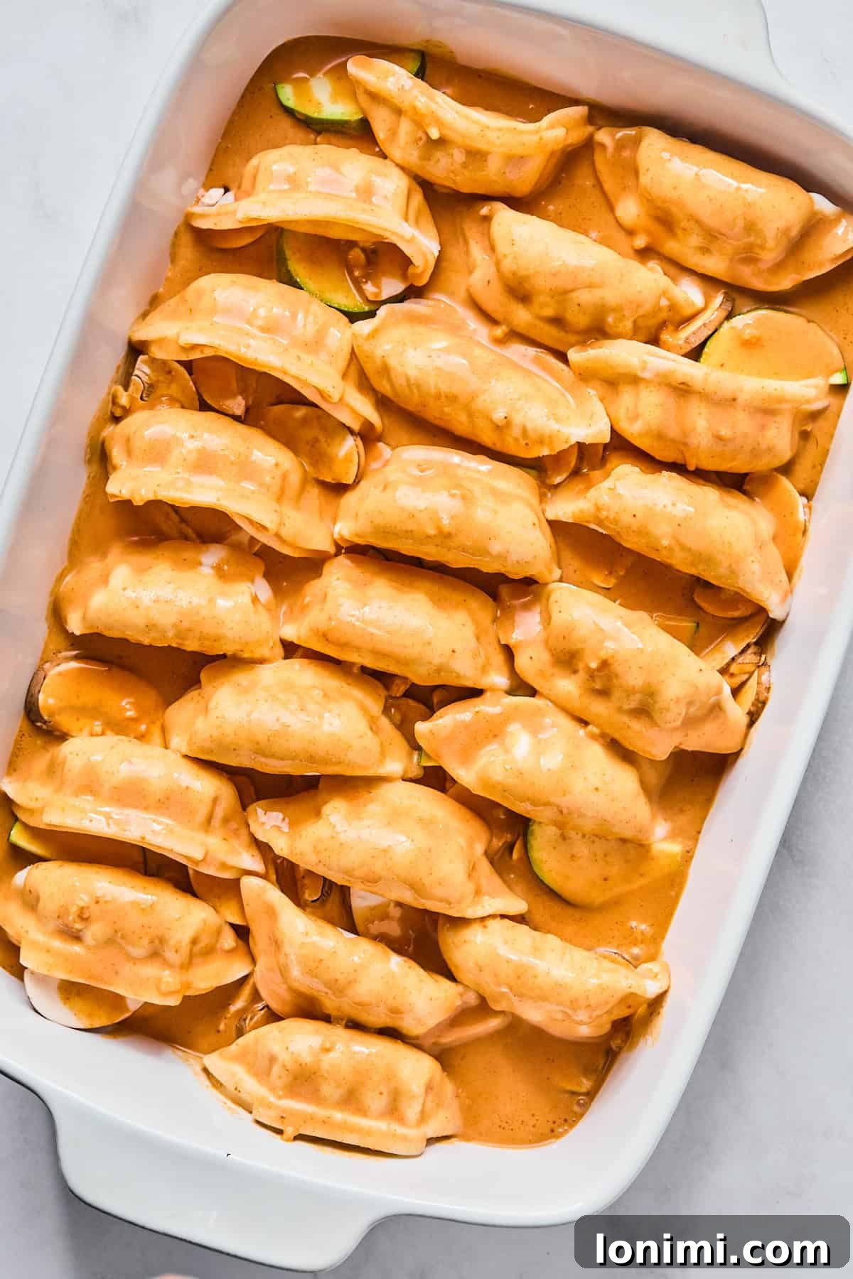 dumplings with red sauce in a casserole dish