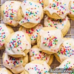 Italian wedding cookies with sprinkles piled on a cooling rack