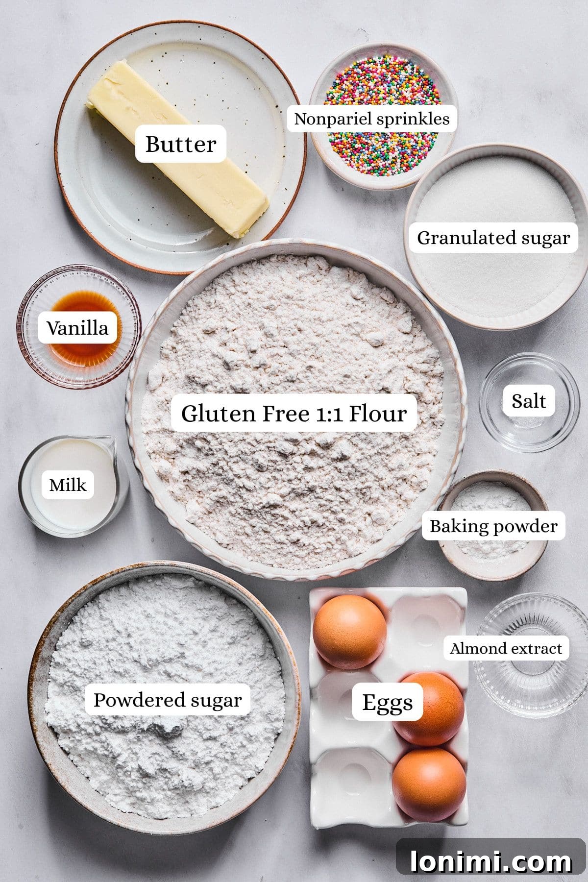 Organized display of all ingredients required for gluten free Italian wedding cookies, including gluten-free flour, butter, eggs, and various extracts.