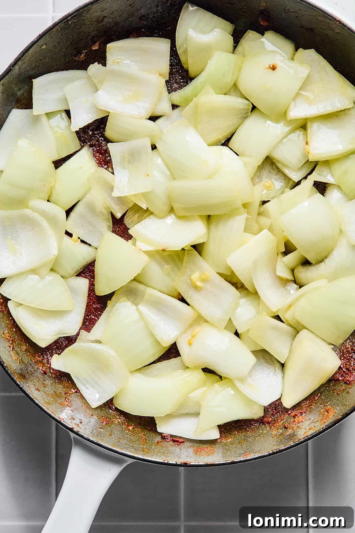 Chopped onion and minced garlic added to the skillet, sautéing until fragrant.