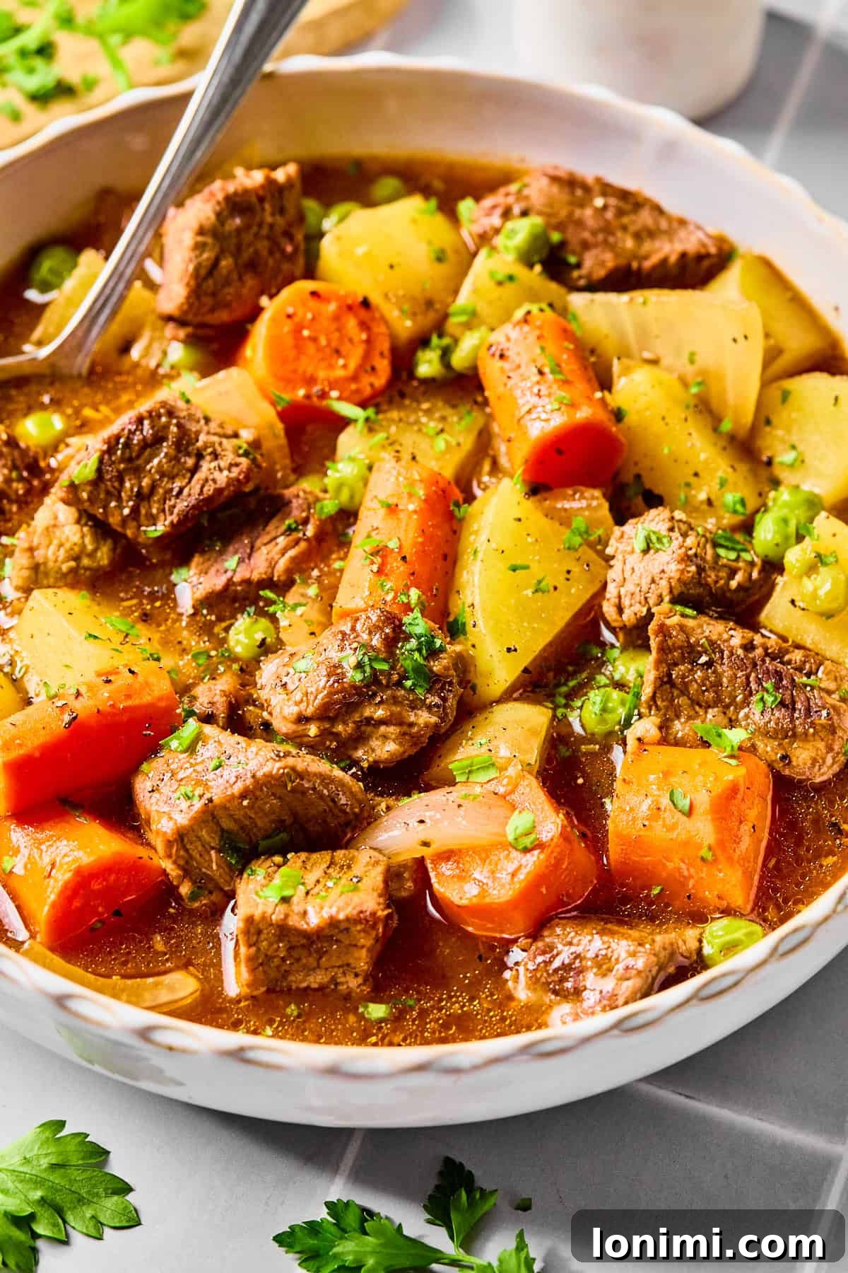 A beautifully presented bowl of slow cooker beef stew, garnished with fresh parsley and ready to be enjoyed.