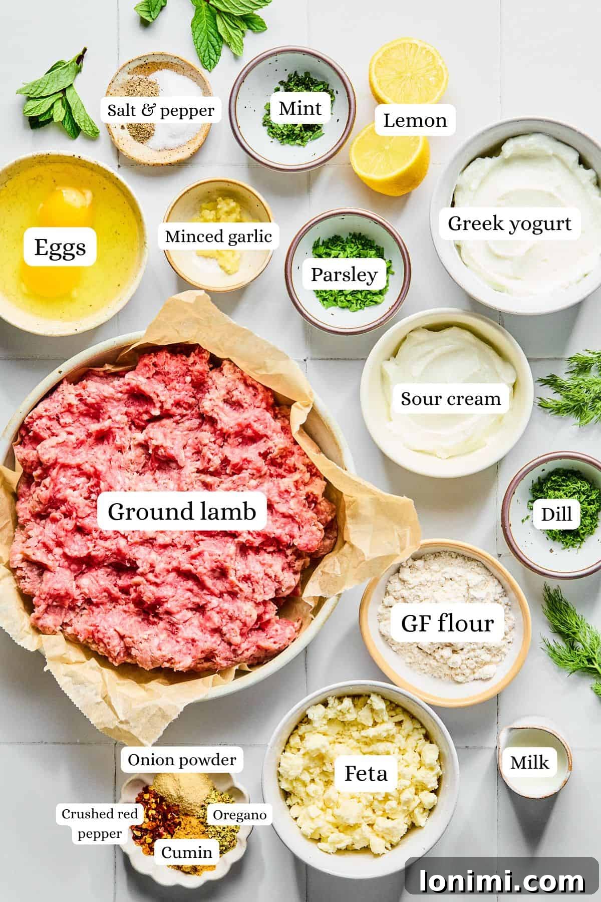 Easy Greek Lamb Meatballs with Zesty Lemon Dill Yogurt 3 Greek lamb meatball ingredients laid out in nesting bowls on a white countertop.