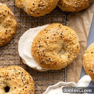 cottage cheese bagel sandwich with cream cheese on a cooling rack with other bagels