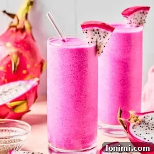 dragon fruit smoothies in 2 cups surrounded by dragonfruit pieces