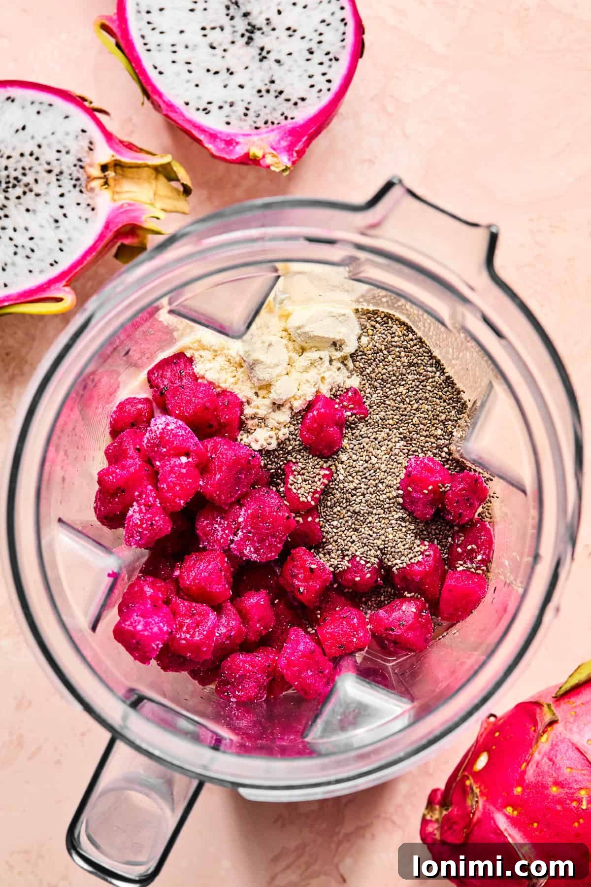 Frozen dragon fruit, banana slices, vanilla protein powder, chia seeds, and coconut water in a high-speed blender.