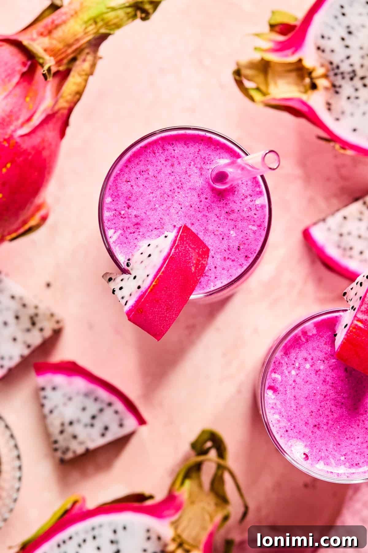 Bird’s eye view of a bright pink dragonfruit smoothie topped with a slice of dragonfruit on the rim.