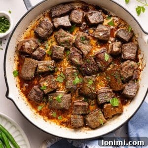 steak bites in a pan with garlic, butter, and parsley
