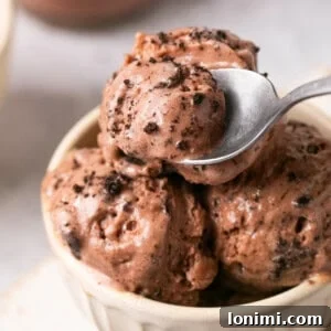 Ninja Cream chocolate protein ice cream in a white bowl with a spoon taking a scoop out