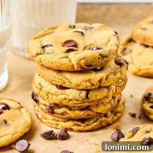 a stack of gluten free chocolate chip cookies on parchment surrounded by cookies