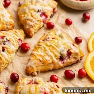 gluten free scones with orange and cranberry on a piece of parchment paper