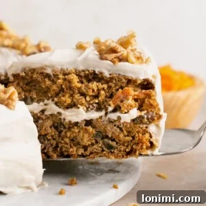 a slice of gluten free carrot cake being pulled out of the whole cake with a spatula