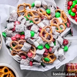 gluten free reindeer chow / Christmas Muddy Buddies in a holiday tin with tissue paper surrounded by mix-ins
