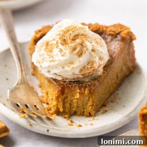 gluten free pumpkin pie on a plate topped with whipped cream