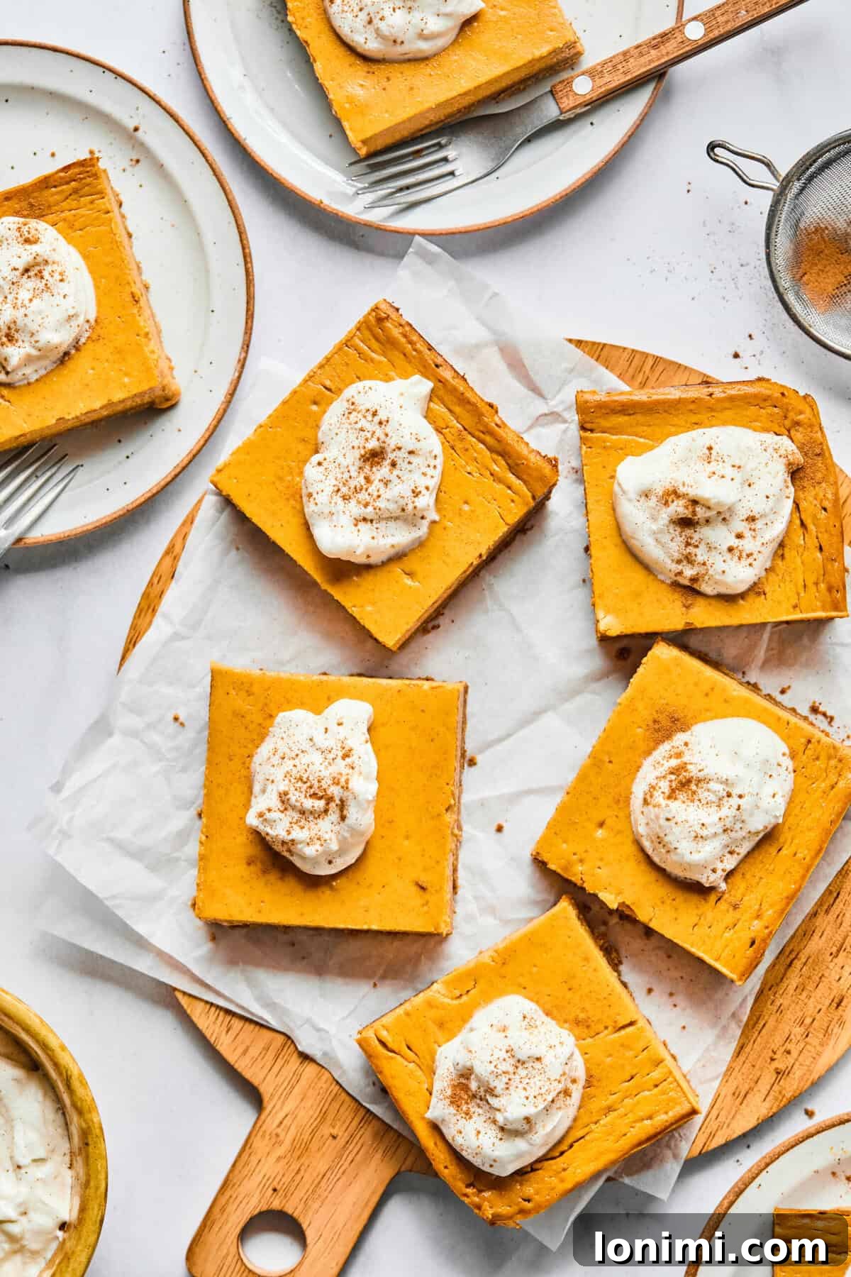 Protein pumpkin bars cut up and topped with whipped cream.