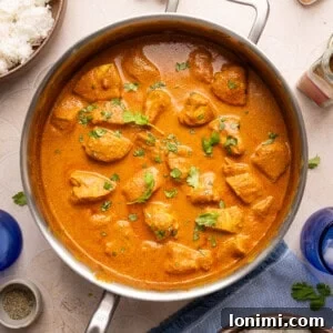 Gluten-free butter chicken simmering in a stainless steel pan, ready to be served.