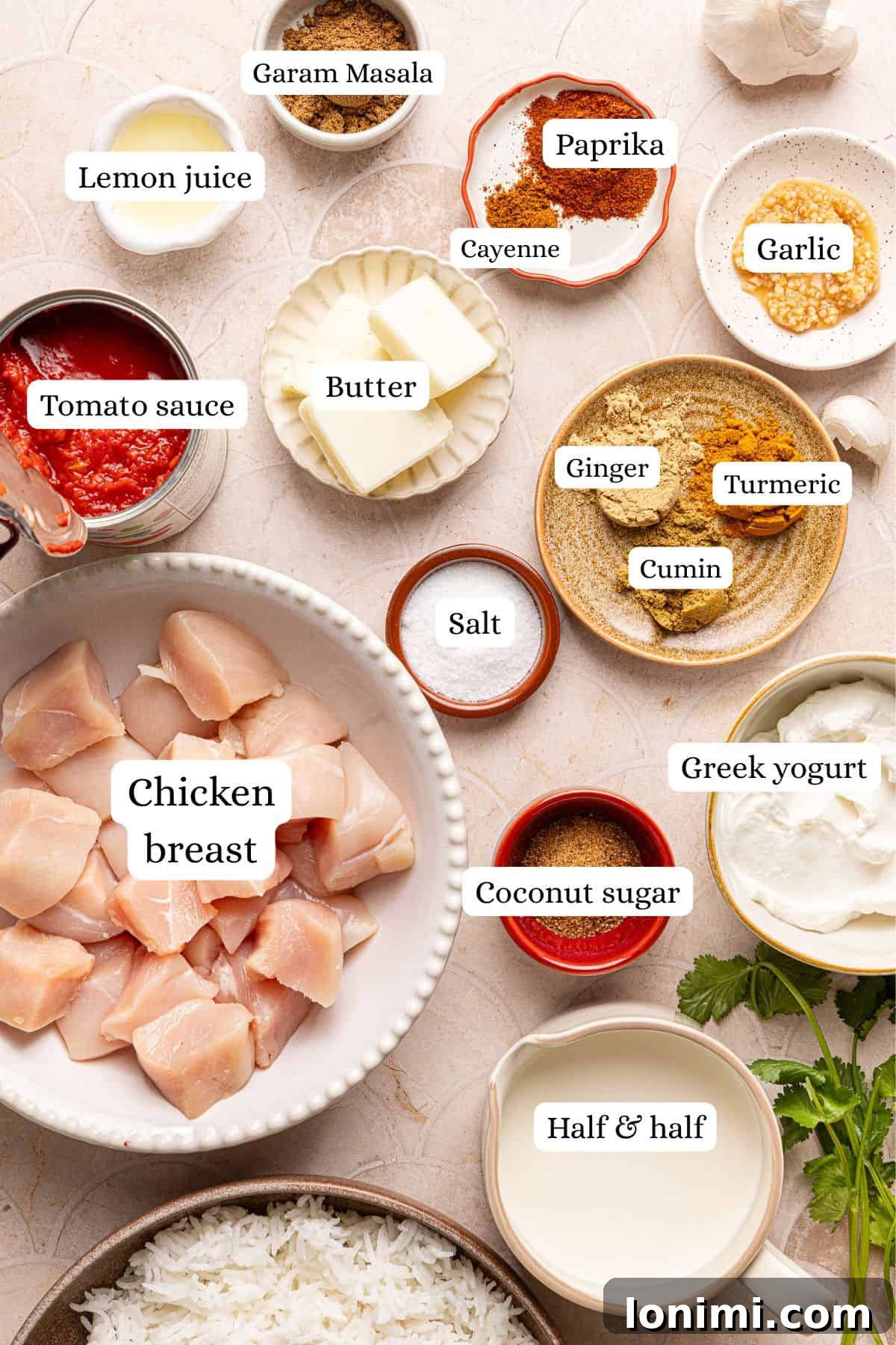 A beautiful flat lay photograph showcasing all the fresh and dry ingredients for butter chicken arranged in elegant nesting bowls, ready for cooking.