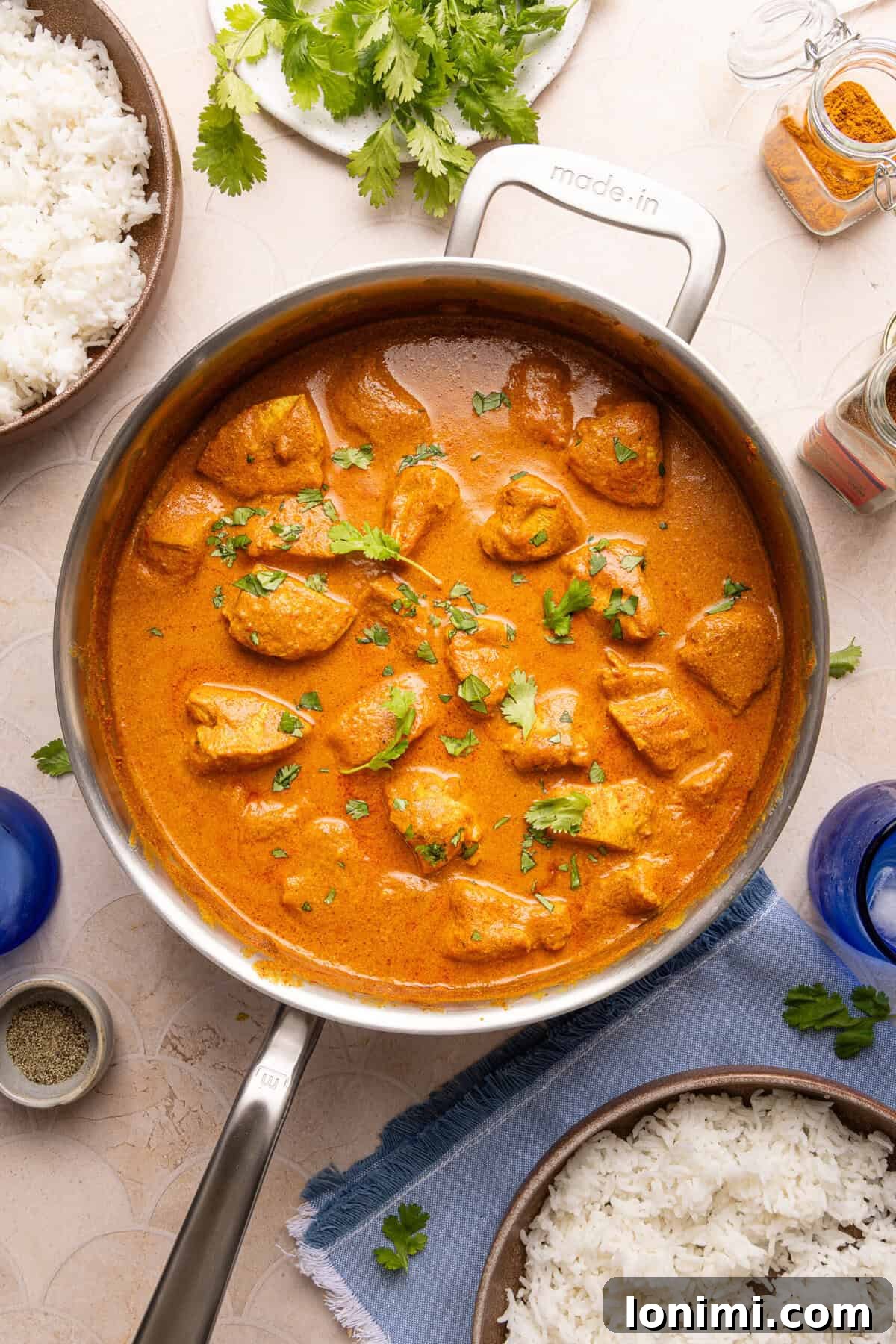Close-up of the finished gluten-free butter chicken simmering gently in a stainless steel pan, looking rich and creamy.