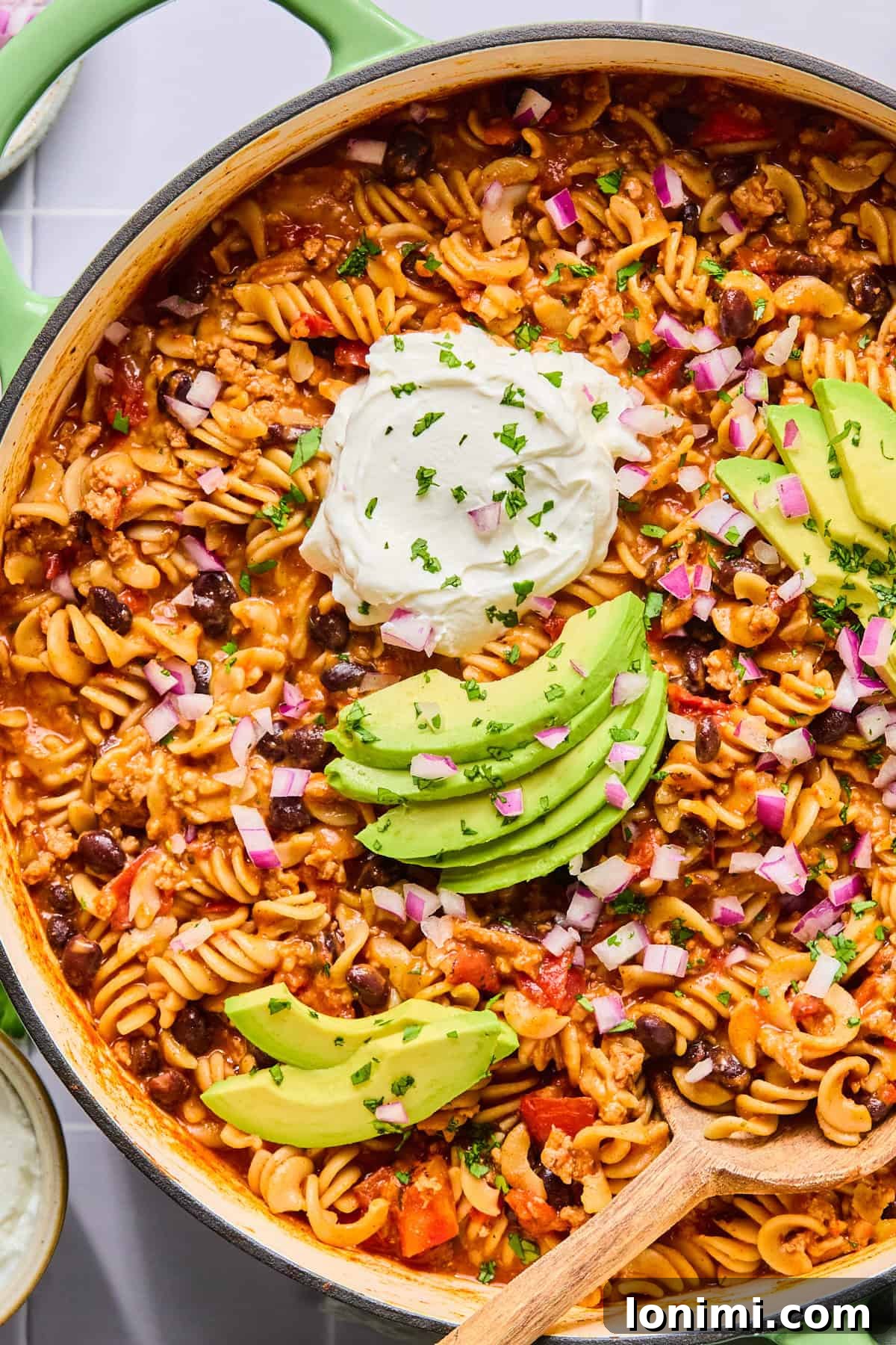 Easy Gluten-Free One Pot Taco Pasta 2 Close-up of one pot taco pasta topped with avocado slices, sour cream, and fresh cilantro.