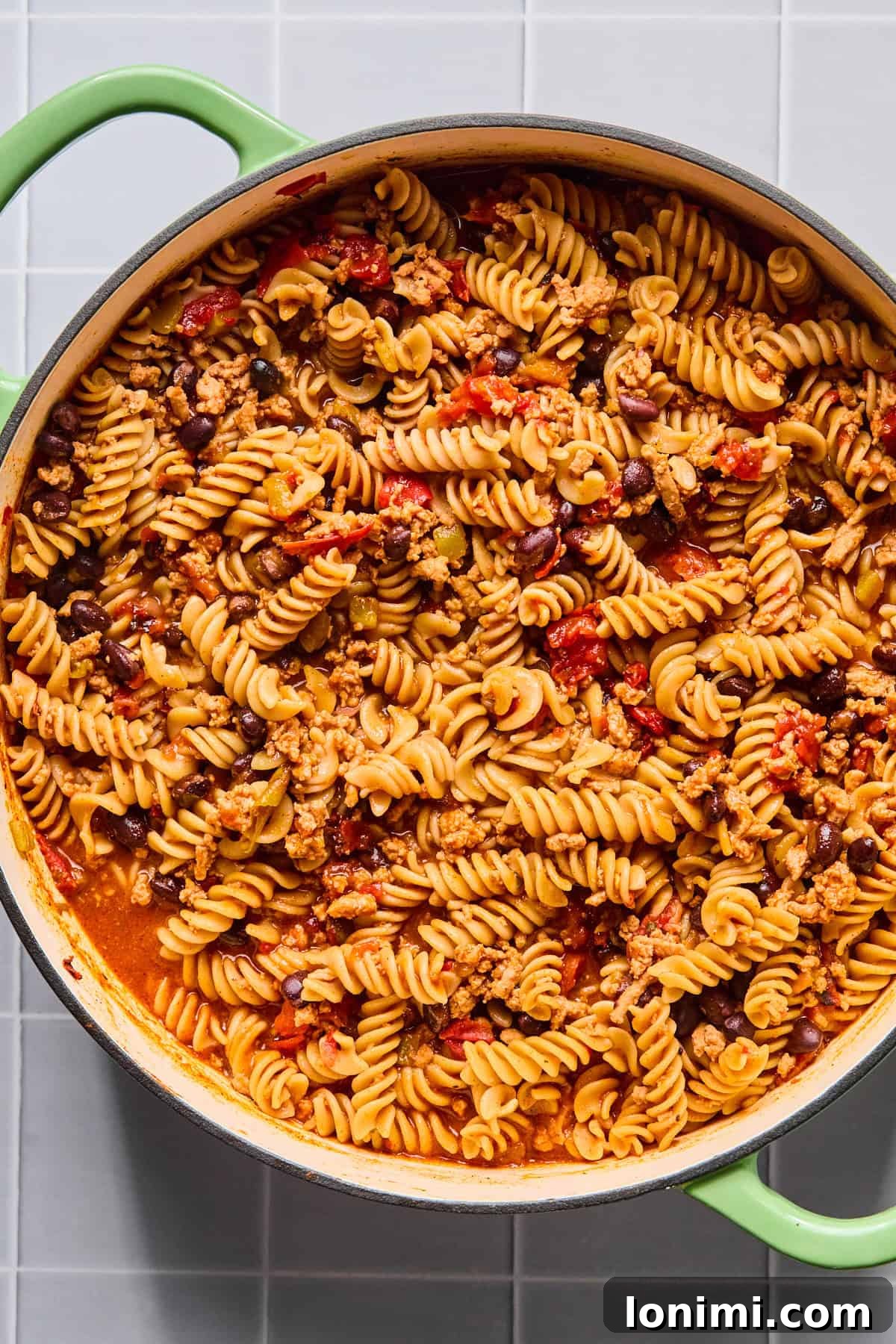 Easy Gluten-Free One Pot Taco Pasta 7 One pot taco pasta simmering in broth as the pasta cooks and absorbs the sauce.