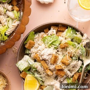 chicken caesar pasta salad in a bowl with a silver fork
