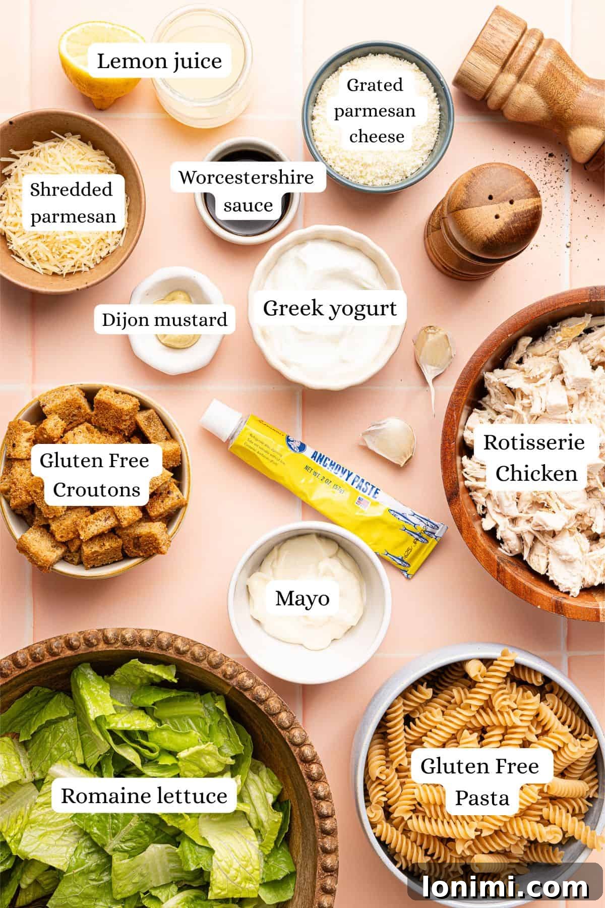 ingredients for chicken caesar pasta salad in nesting bowls