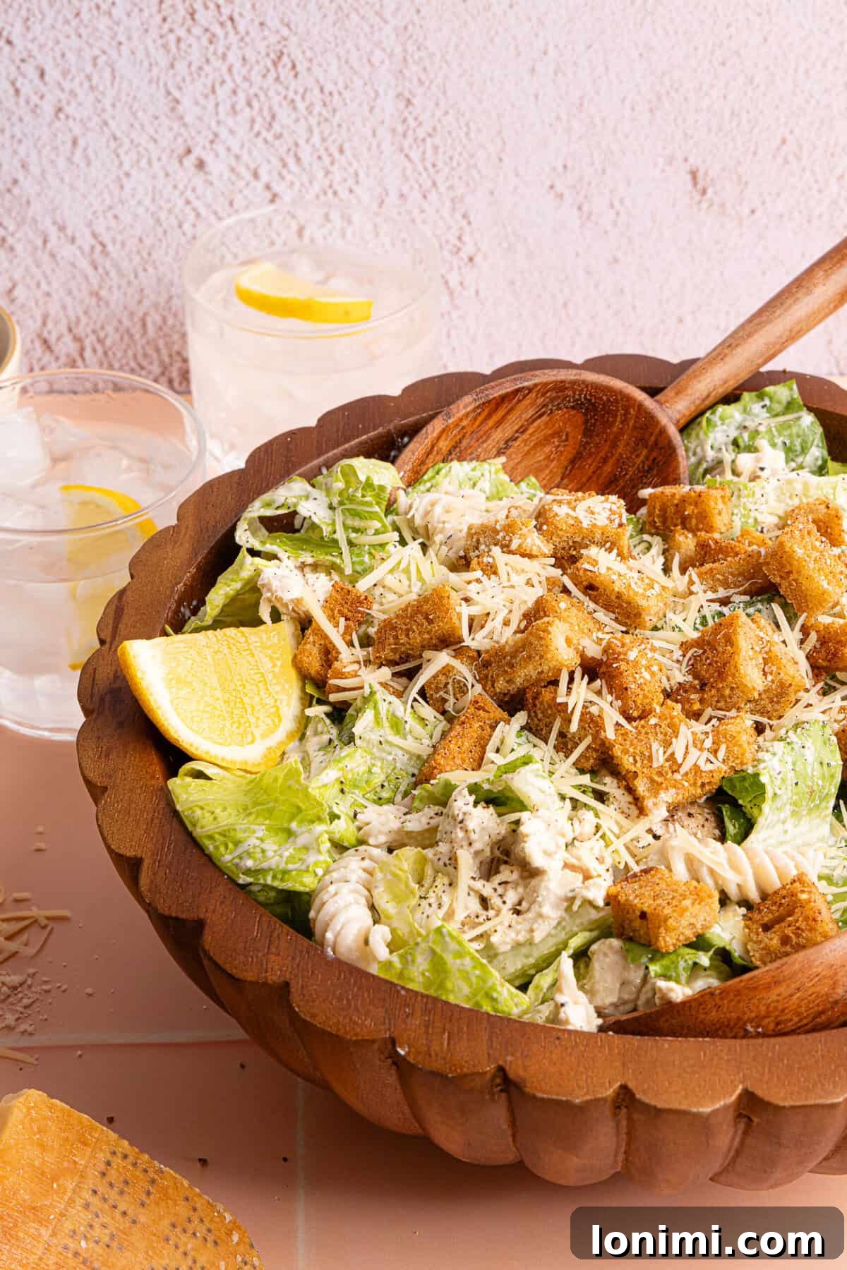 a side view of a bowl of chicken pasta salad with lettuce