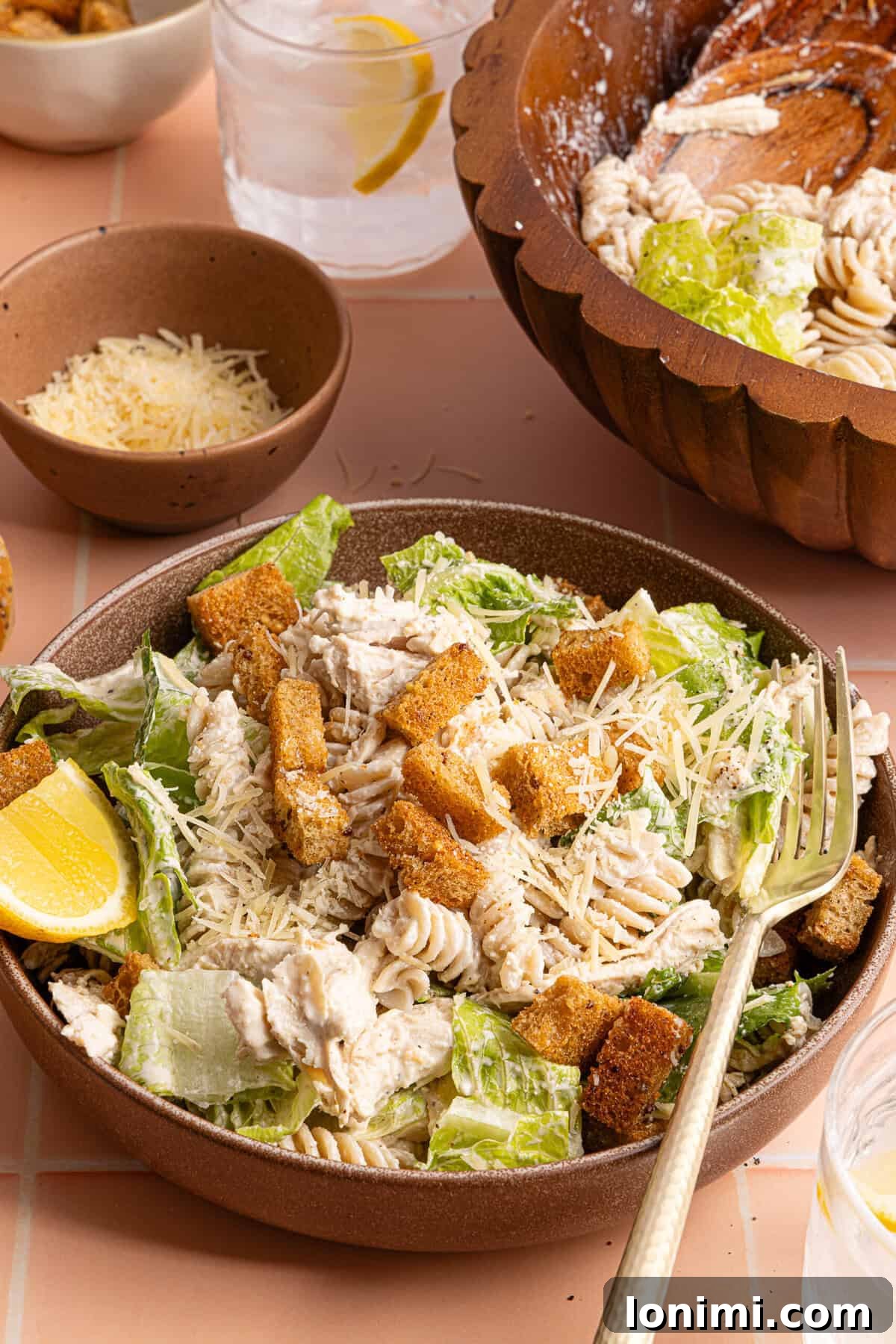a side view of a bowl of chicken caesar pasta salad