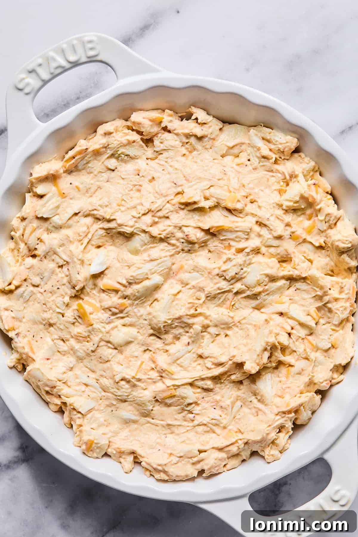 Ultimate Creamy Crab Dip Warm or Cold 7 Crab dip mixture spread evenly into a baking dish before baking.