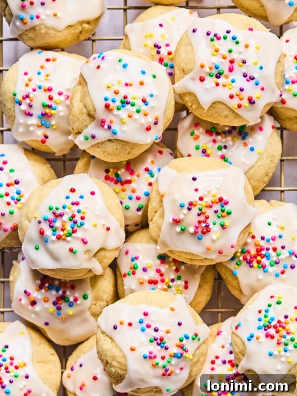 Gluten-Free Strawberry Shortcake with Homemade Biscuits Recipe 16 Italian wedding cookies with sprinkles piled on a cooling rack